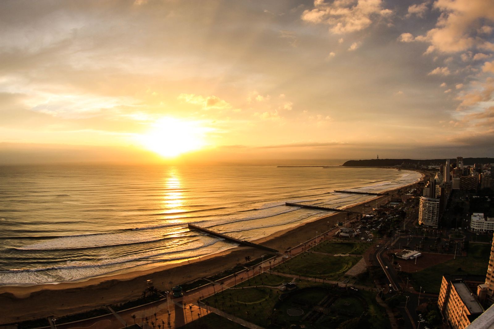Sunrise over Durban's beachfront and piers, looking north along the KwaZulu-Natal coastline.