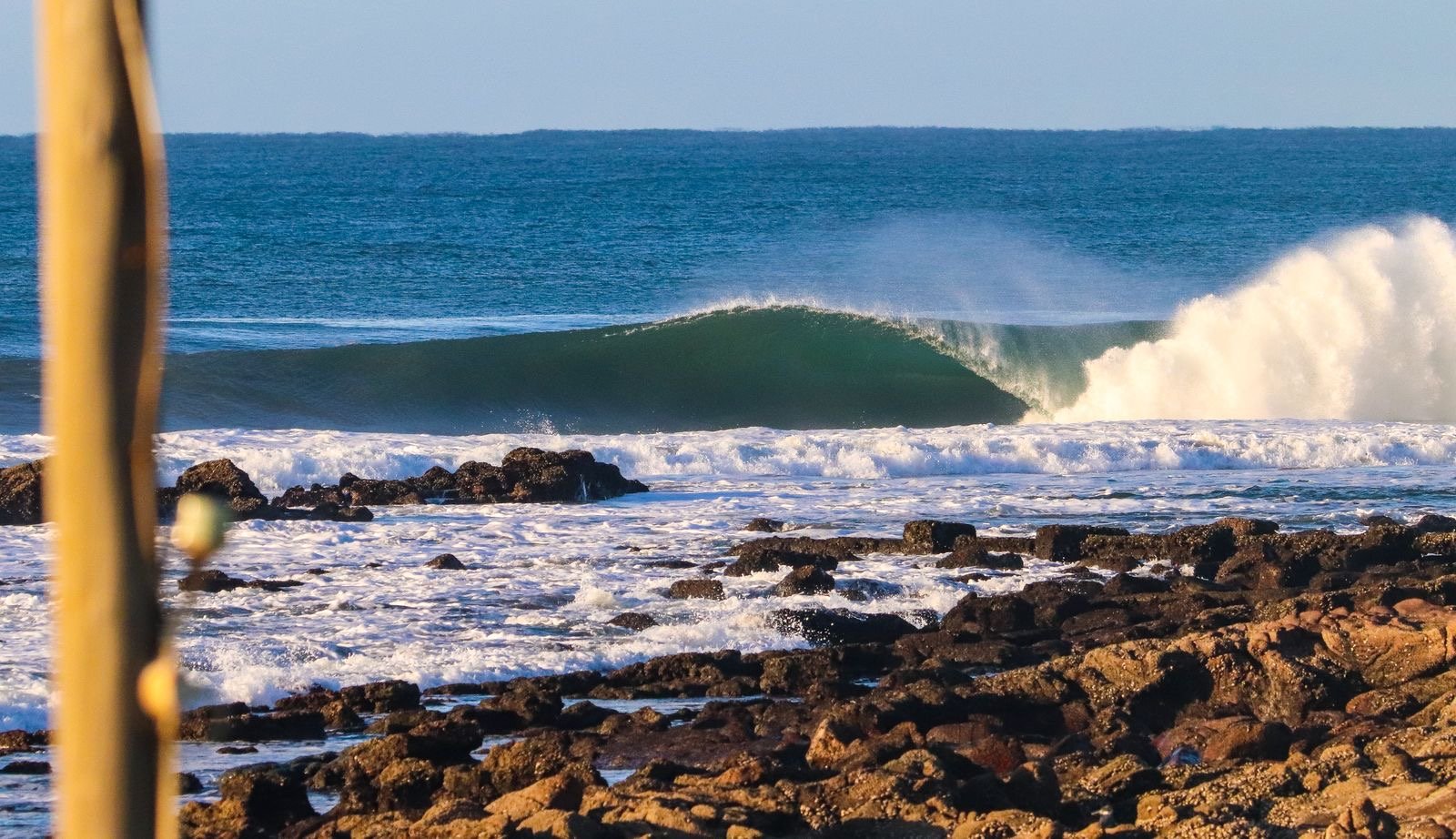 A green barrel peeling over a rock reef on the KwaZulu-Natal coast.